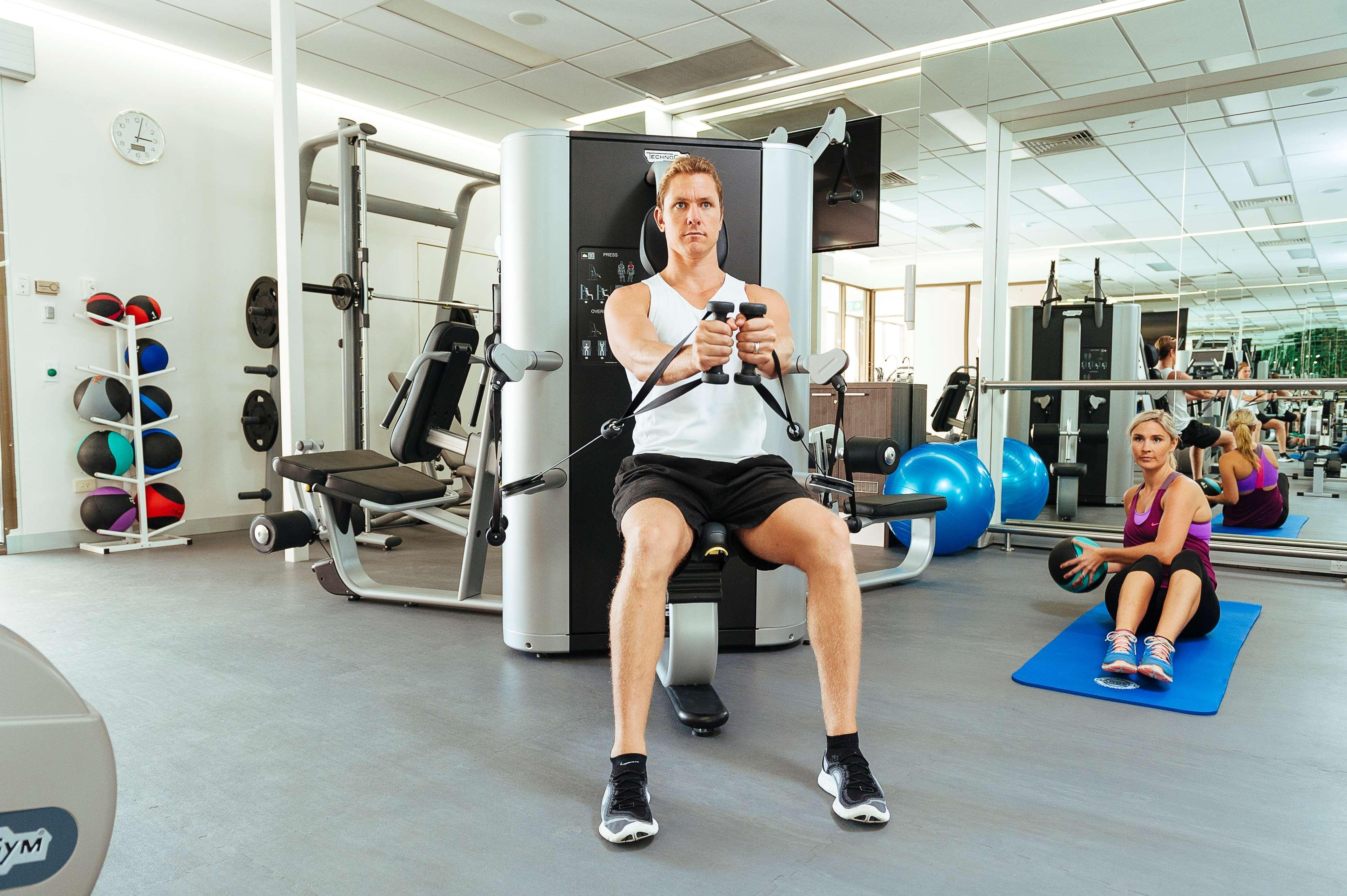 Stamford Plaza Adelaide Hotel Exterior foto The photo shows a gym setting with two individuals engaged in workout activities. 

In the foreground, a man is seated on a machine, using the handles to perform a rowing exercise. He is wearing a sleeveless shirt and shorts, indicating an active wor